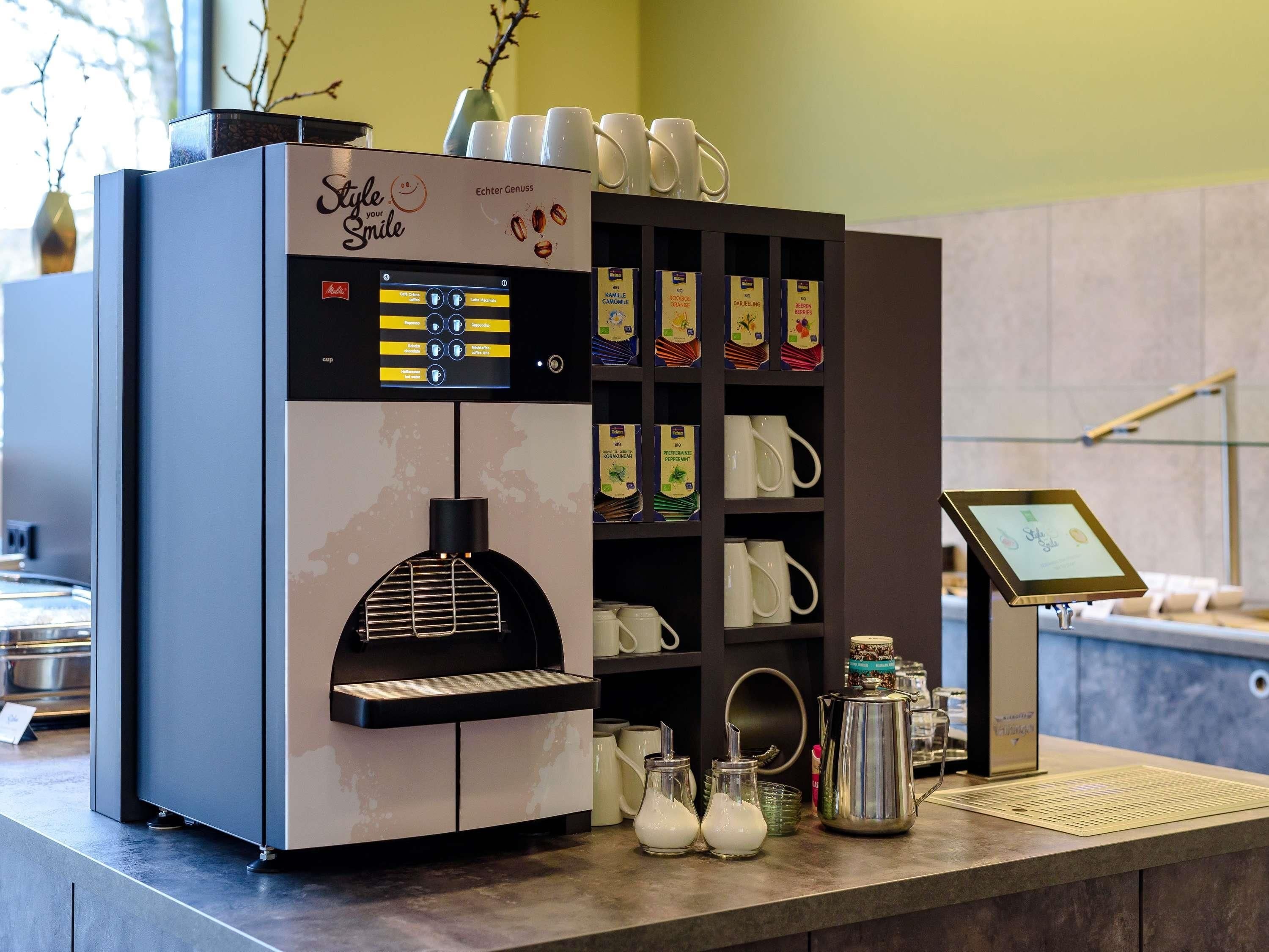 A coffee machine with a digital display, a milk frother, and a coffee bean dispenser.