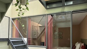 Un interior moderno con una escalera, una cama y una planta colgante.