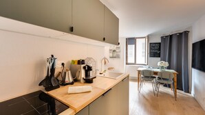A modern kitchen with a wooden countertop, built-in appliances, and a dining area with a table and chairs.