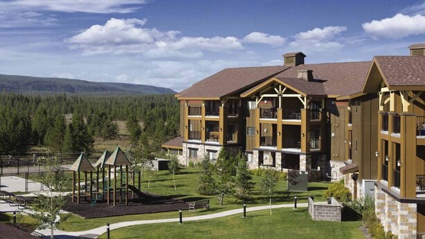 A lodge with a central courtyard, multiple balconies, and a playground area.