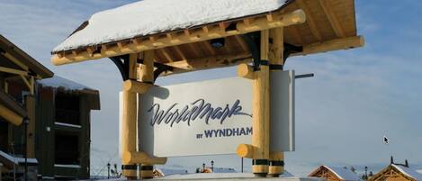 Puinen kyltti, jossa lukee ”Wynhammark” ja ”BY WYNDHAM”, ja joka on kiinnitetty puiseen tukirakenteeseen.