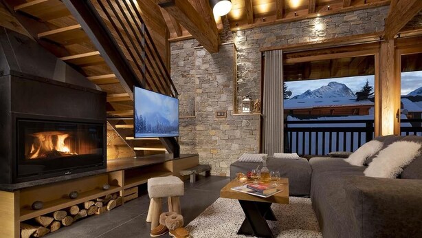 A cozy living room with a fireplace, a television, and a sofa. - Chalet, wifi, 150m from ski slopes, sauna, terrace, fireplace or stove, tv, 260m², Les 2 Alpes (Les Deux Alpes)