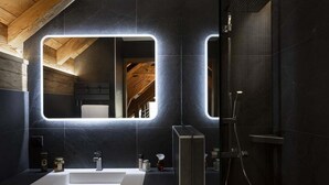 A modern bathroom with a large mirror, a shower, and a sink. - Chalet, wifi, 150m from ski slopes, sauna, terrace, fireplace or stove, tv, 260m², Les 2 Alpes (Les Deux Alpes)