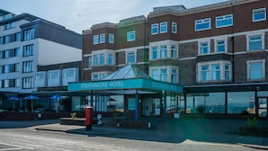 A Strathmore Hotel with a modern facade, large windows, and a covered entrance area.