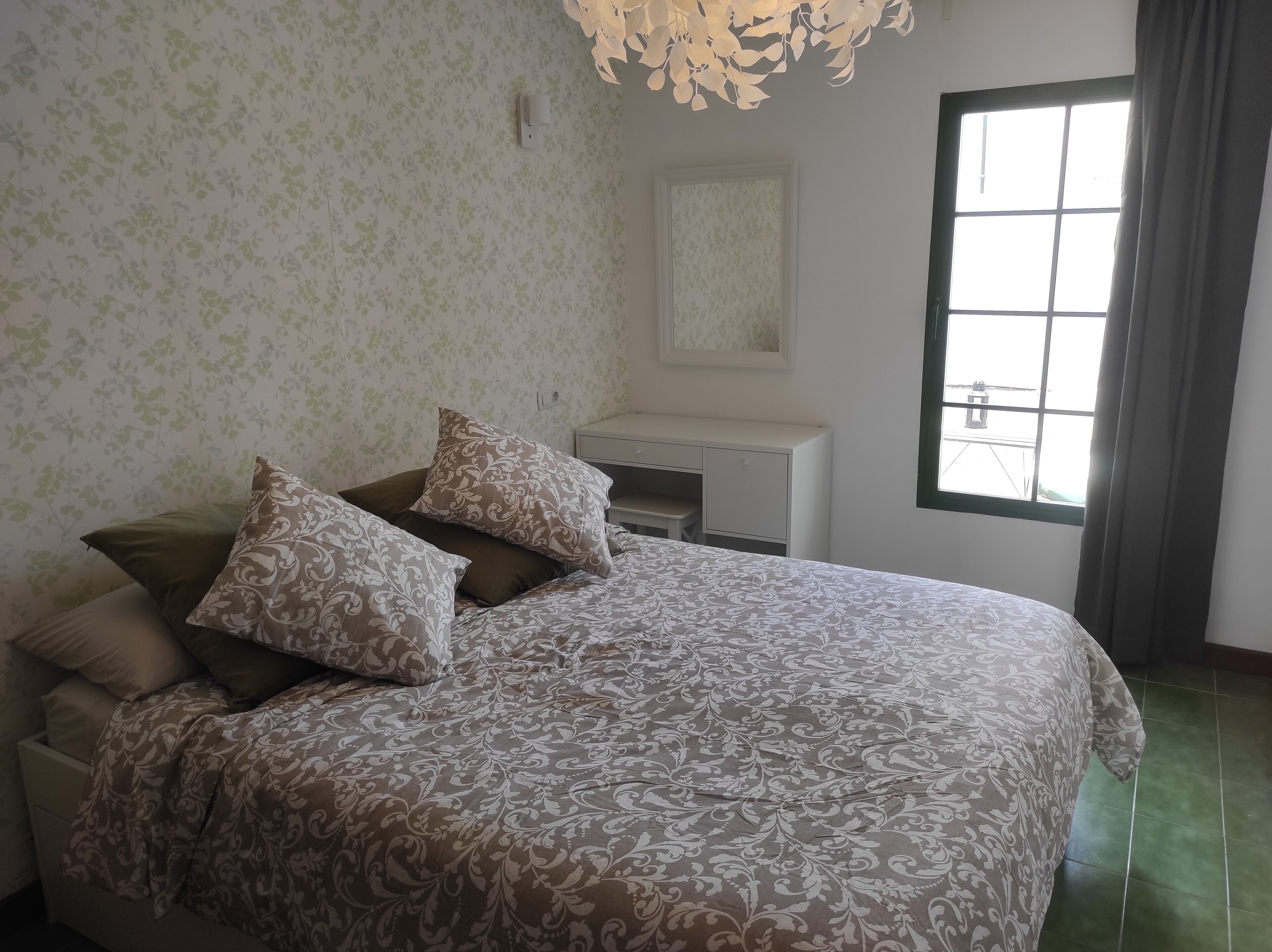 Une chambre à coucher avec un lit, un bureau et une fenêtre.