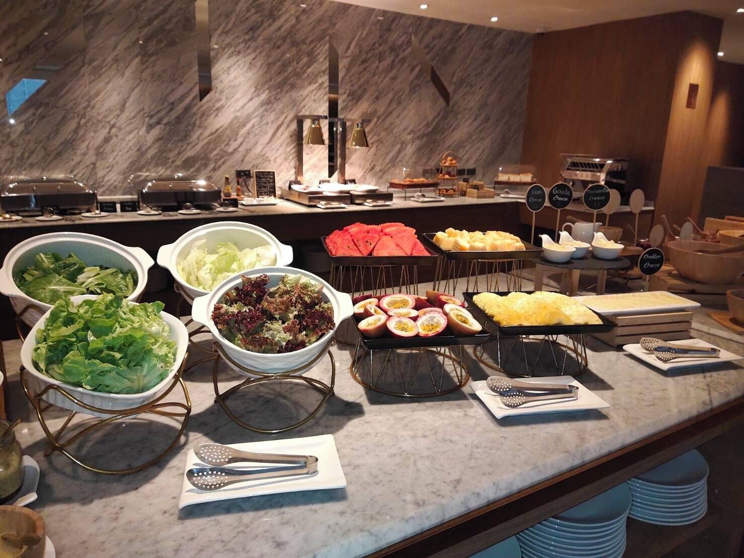 A buffet with various food items and utensils.