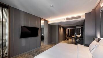 Een moderne hotelkamer met een groot bed, een flatscreen televisie aan de muur en een inloopkast.