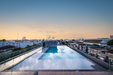 Una piscina al aire libre, sillones reclinables de piscina