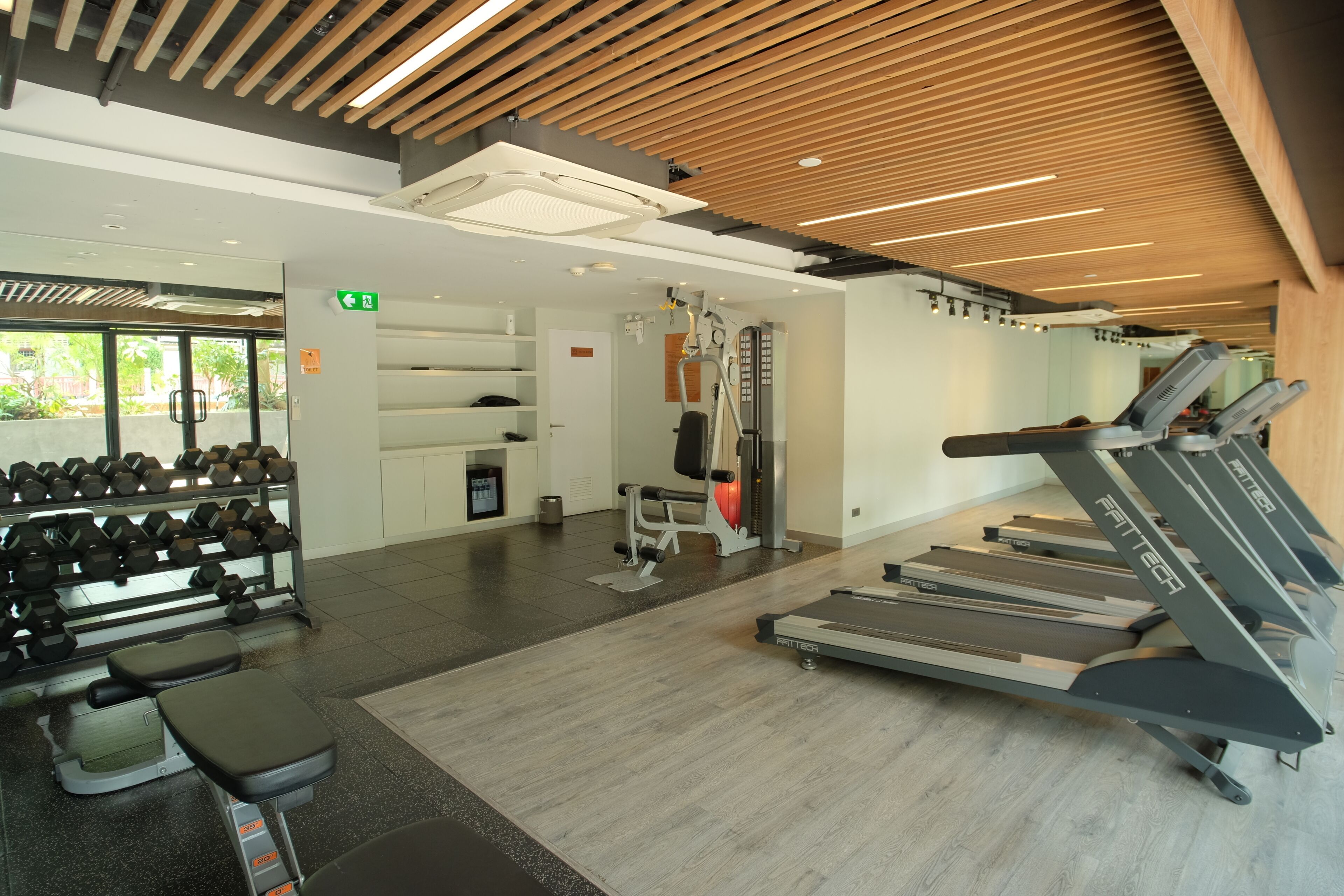 A gym with treadmills, dumbbells, and weight machines.
