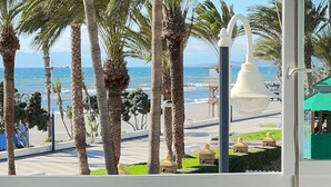 Une vue d’une plage avec des palmiers et un lampadaire.