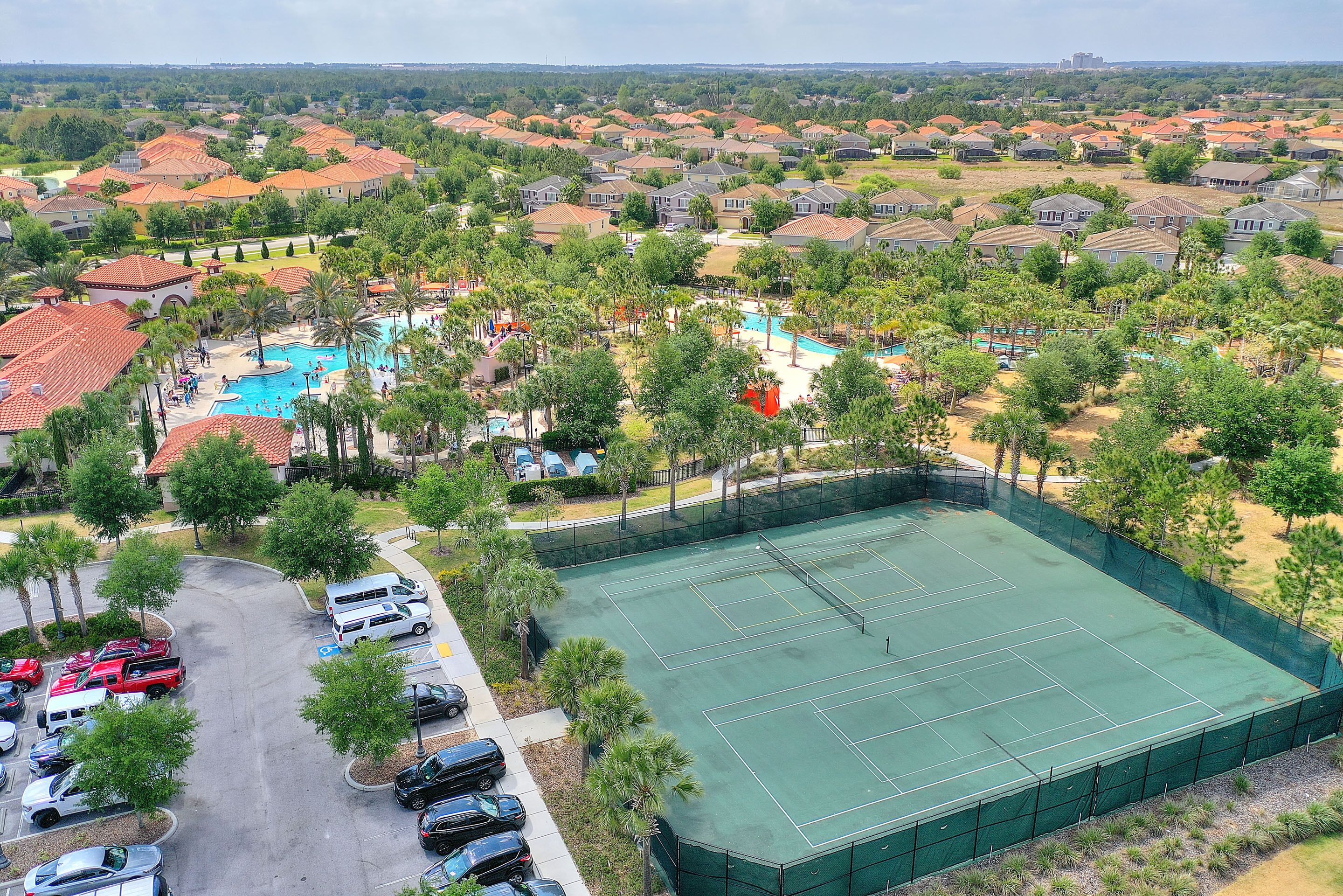 Zona residenziale con campo da tennis, piscina e parcheggio.