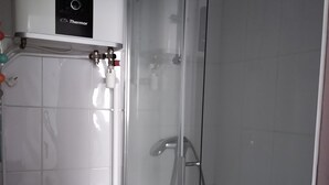 A bathroom with a toilet, sink, and a glass-enclosed shower area.