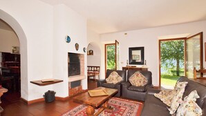 Una sala de estar con chimenea, un sofá, una mesa de centro y una alfombra estampada.