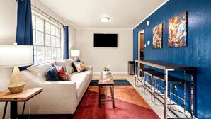 A modern living room with a sofa, coffee table, and a TV.