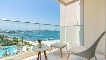 Un balcón con vistas al mar, una piscina y un paisaje urbano.