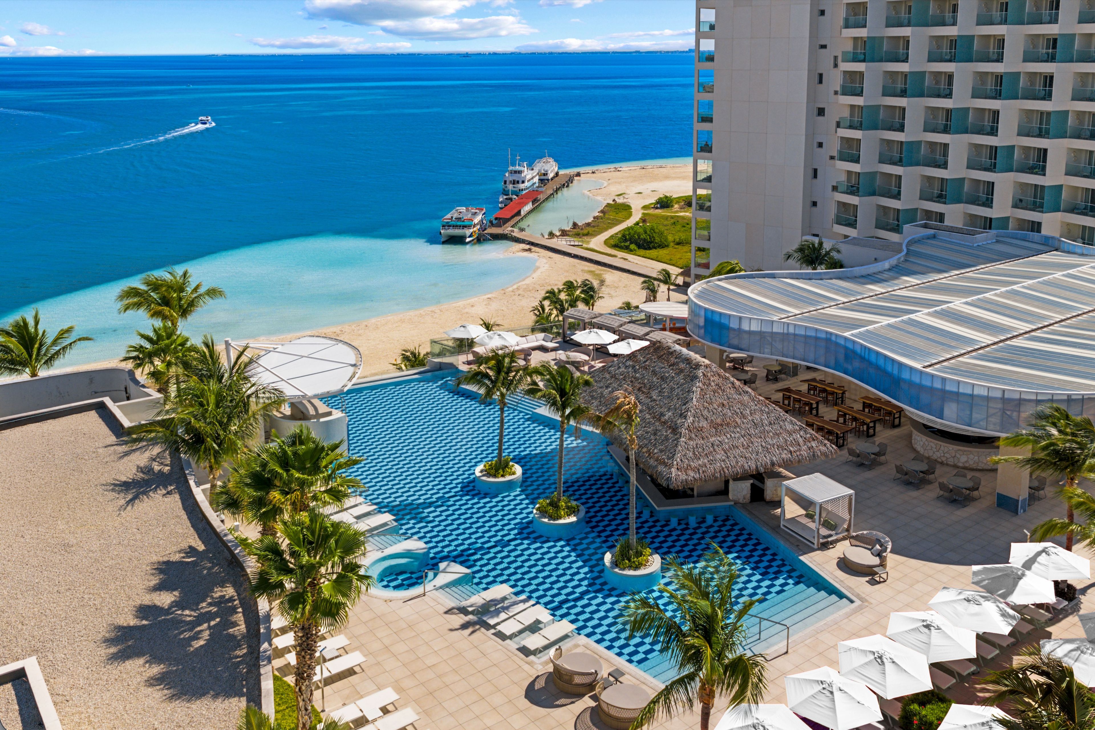 Un resort con piscina, playa y vista al océano.