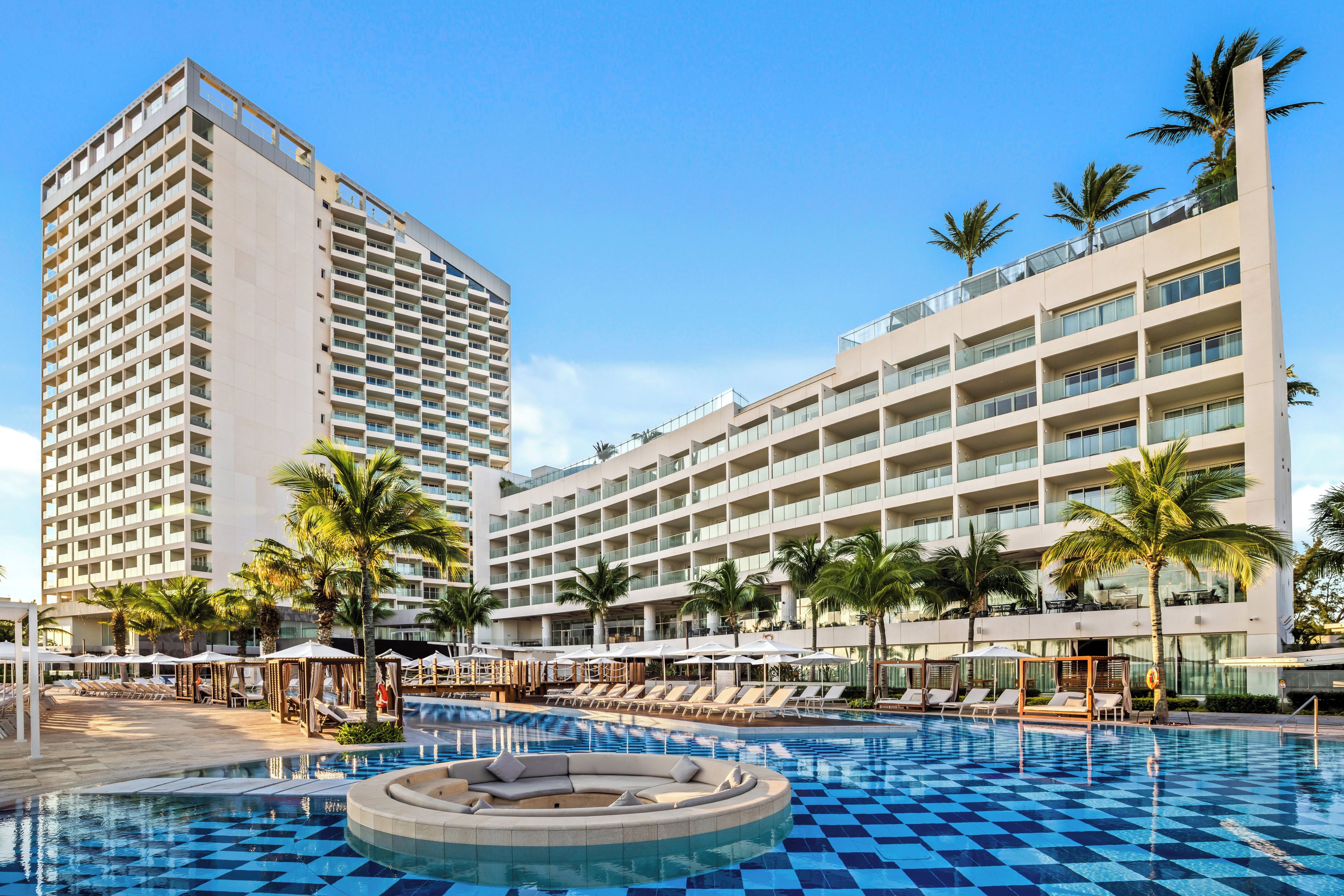 Ein Hotel mit Pool, Palmen und modernem Design.