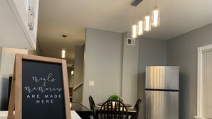 A modern kitchen with a chalkboard sign, stainless steel refrigerator, and pendant lighting. - The Roulette Duplex-Private Yard&Parking (Niagara Falls)