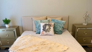 A bedroom with a bed, a fluffy rug, and two nightstands with drawers. - The Roulette Duplex-Private Yard&Parking (Niagara Falls)