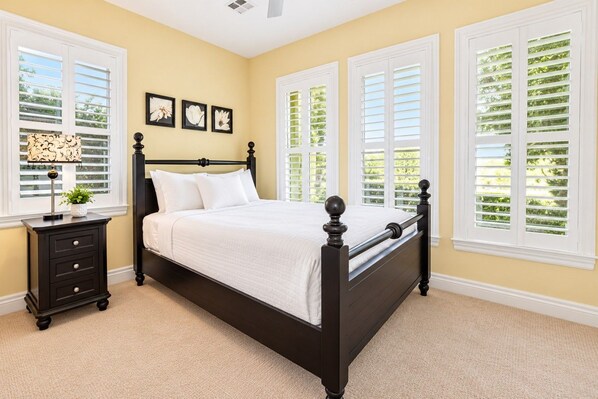 A bedroom with a bed, a nightstand, and a window with shutters. - Private Pool & Outdoor Kitchen (Hurricane)