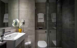 Une salle de bain moderne avec un lavabo, des toilettes et une douche à parois de verre.