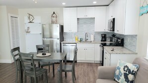A modern kitchen with white cabinets, stainless steel appliances, and a granite countertop.
