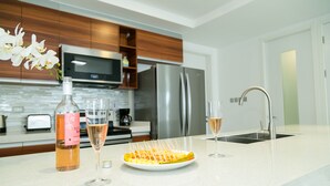 A modern kitchen with a white countertop, stainless steel appliances, and wooden cabinets. - 20 South Apartments (Kingston)