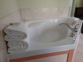 Un baño con lavamanos blanco, dos llaves y un toallero con toallas dobladas.