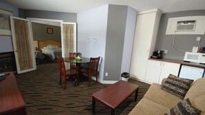 A compact living space with a dining area, kitchenette, and a bedroom. - North Bay Inn (North Bay)