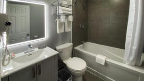 Standaard kamer | Badkamer | Een haardroger, handdoeken, zeep, shampoo