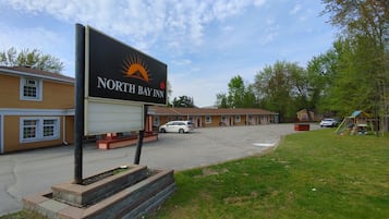 A North Bay Inn with a large sign, a parking lot, and a playground.