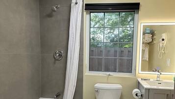 A bathroom with a bathtub, toilet, and sink.