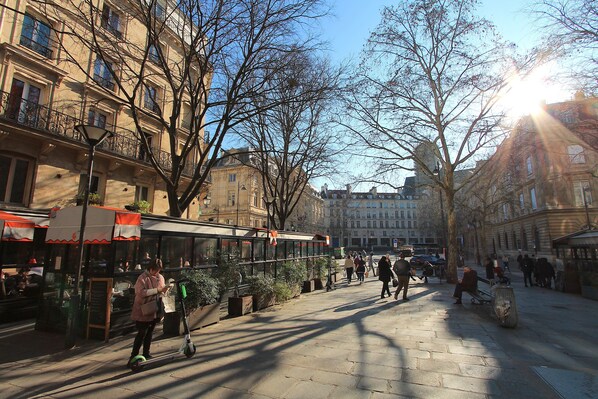 A city street with buildings, a tram, and pedestrians. - Marais - Sicile - Sainte Croix de la Bretonnerie -Gay Paris (Paris)