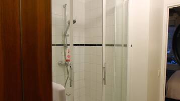 A bathroom with a shower, a toilet, and a sink.