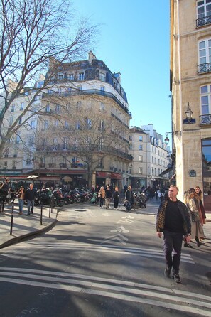 A street scene with pedestrians, parked bicycles, and classic European architecture. - Marais - Sicile - Sainte Croix de la Bretonnerie -Gay Paris (Paris)