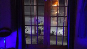 Ein Zimmer mit einer großen Schiebeglasdoor, die auf einen Balkon führt.