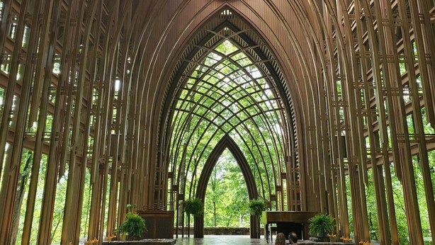 L’intérieur d’une cathédrale, avec un plafond voûté élevé, des rangées de bancs et une allée centrale menant à l’autel.