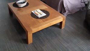 Ein Holztisch mit Zeitschriften, einem Korbwäscher und einem dunklen Boden.