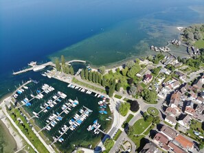 Vista aérea de un puerto deportivo con numerosas embarcaciones amarradas, rodeado de edificios residenciales y vegetación.