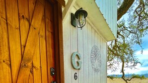 Una puerta de madera con el número 6 y una señal con la letra 'G' en la pared de al lado.
