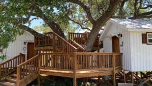 Una terraza de madera con una escalera que lleva a una cabaña.