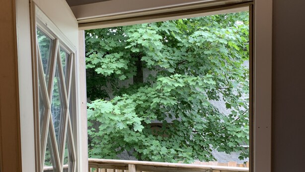 An exit sign above a door leading to an outdoor deck with a table and chairs.