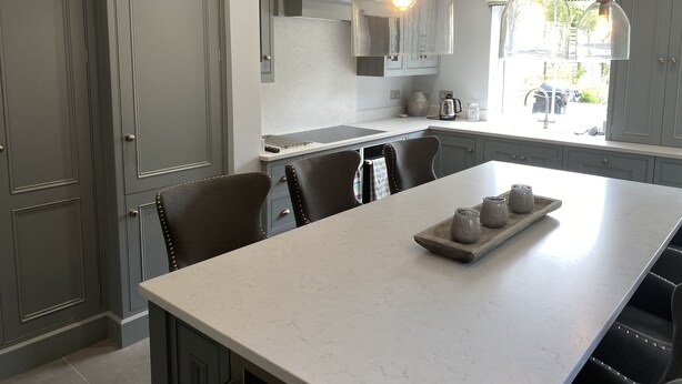 A modern kitchen with grey cabinets, a large island, and pendant lighting. - Ashburn, holiday home close to the beach (Seaview)