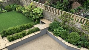 A landscaped patio area with a seating arrangement and a small garden. - Ashburn, holiday home close to the beach (Seaview)