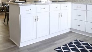 A modern kitchen with white cabinets, a central island, and pendant lighting. - Gulf Coast Condos on the Sand Dunes - 202 (Dauphin Island)