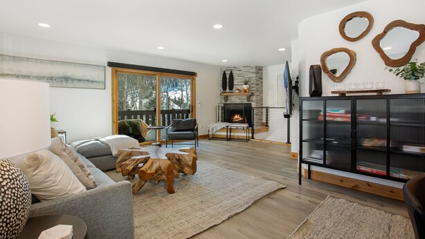 Una sala de estar moderna con chimenea, una mesa de centro de madera y una estantería.