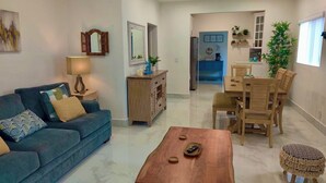A living room with a sofa, coffee table, and a dining area with a table and chairs. - Beautiful Chic Home Near Coconut Grove & Brickell (Miami)