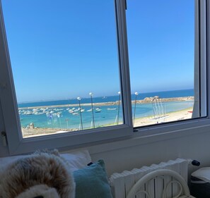 Une chambre avec vue sur un port de plaisance et la mer.