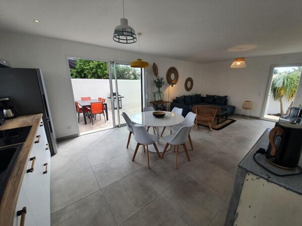A modern kitchen with a dining area, a sofa, and a coffee table.