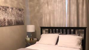 Un lit bien fait, avec du linge de lit blanc, dans une chambre d'hôtel.